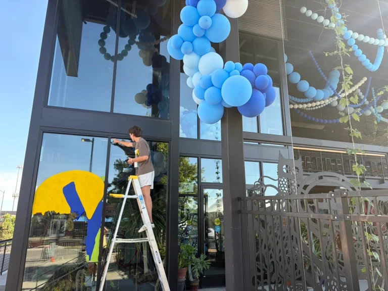 Technician cleaning a storm window with a squeegee